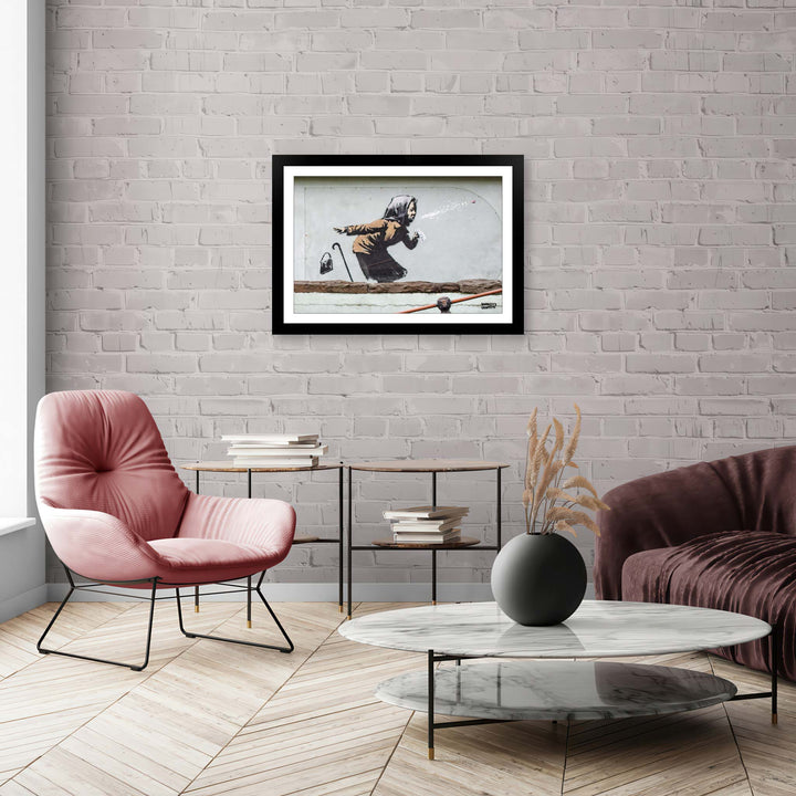 Achoo, a framed print of Banksy's Graffiti-Homekor Mounted in a cozy room