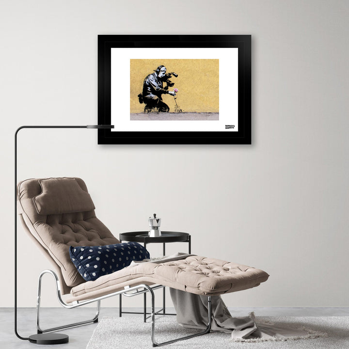 Flower Puller, a framed print of Banksy's Graffiti-Homekor Mounted in a cozy room