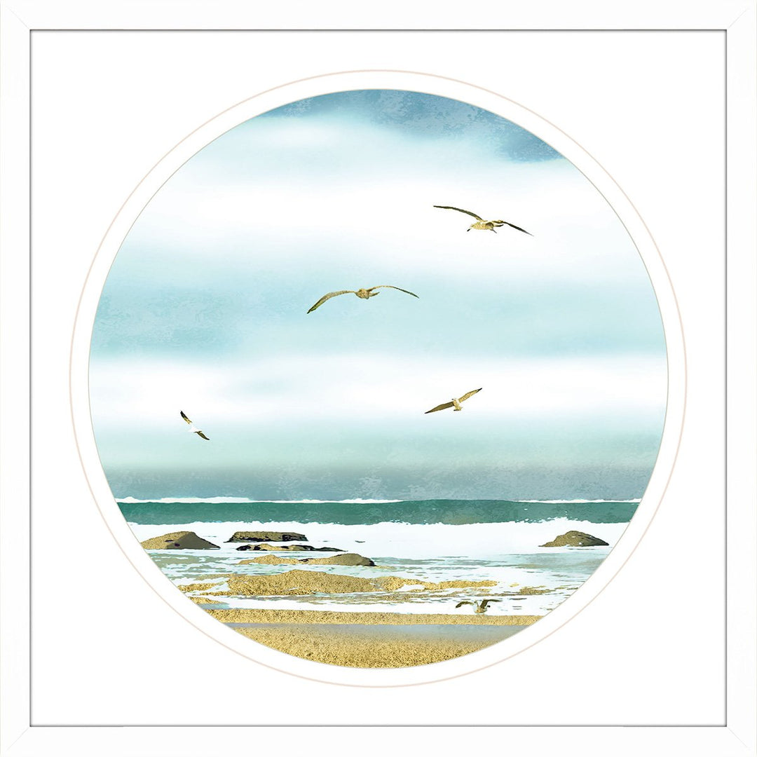Framed wall art with birds flying above beach sand and ocean.