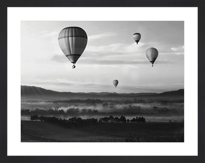 Photography wall art of hills and valleys with hot air balloons in the air.