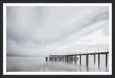 Black and white photography wall art of a pier with morning fog.