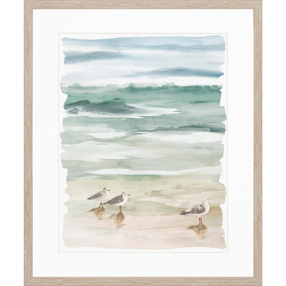 Watercolor painting framed art of beach with seashore birds walking along sand.